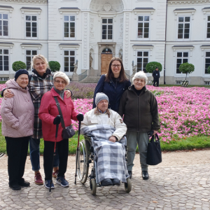 Sześć osób stojących na tle Belwederu w Łazienkach Królewskich.