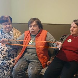 Panie ćwiczą oddech rozciągając gumę.jpg