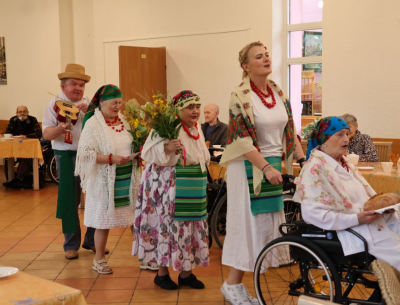 Mieszkańcy w orszaku idą z plonami