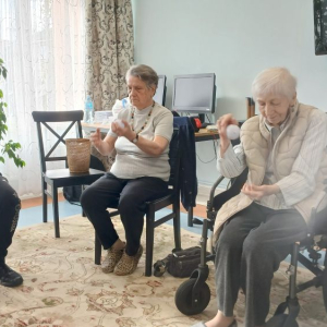 Trener pokazuje Mieszkankom ćwiczenie z piłką.jpg