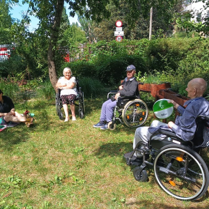 Pięciosobowa grupa relaksująca się w ogrodzie