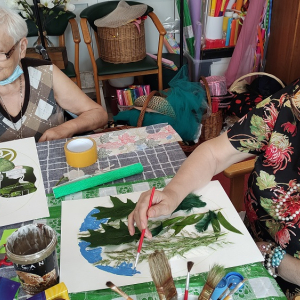 Dwie kobiety tworzące prace plastyczne z wykorystaniem liści