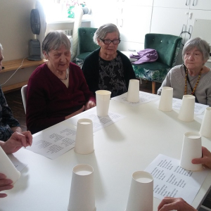 Grupa Seniorów siedząca wokół stołu